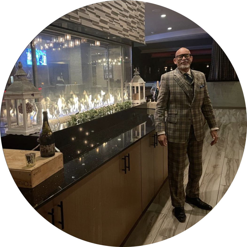 A man in a suit standing next to a bar.