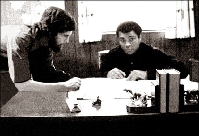 Two people sitting at a table looking at papers.